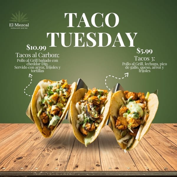 Three chicken tacos with green sauce and toppings in a metal holder on a wooden table.